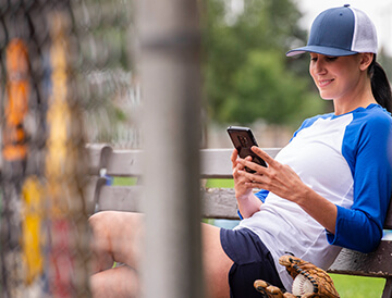 Woman looks at her Android phone at a baseball game